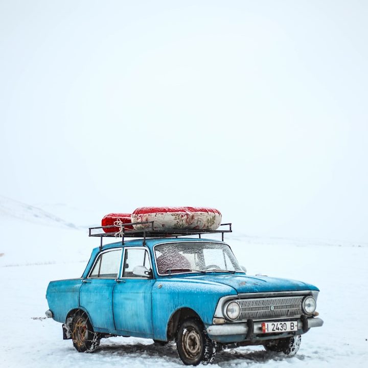 Blauer Oldtimer Blauer Oldtimer mit Dachgepäckträger in verschneiter Winterlandschaft.